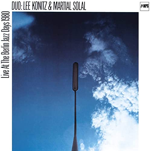 CD cover: blue sky with clouds, a dark pole, and text details.