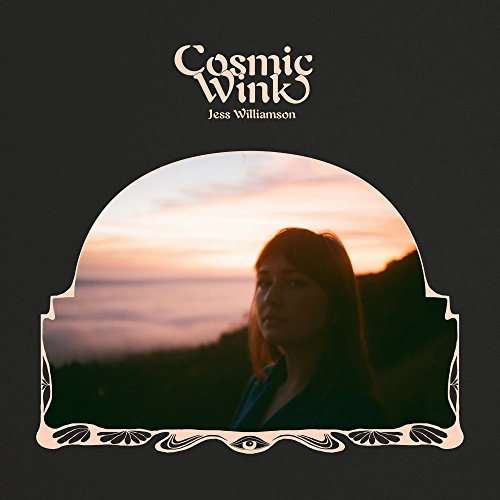 "Album cover with a woman's portrait against a sunset, ornate frame, black background."