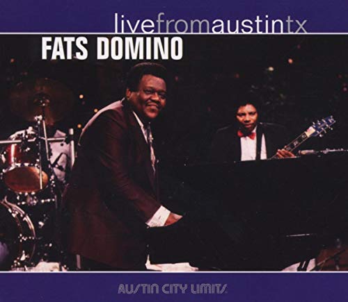 Fats Domino at a piano with a band, live concert setting.