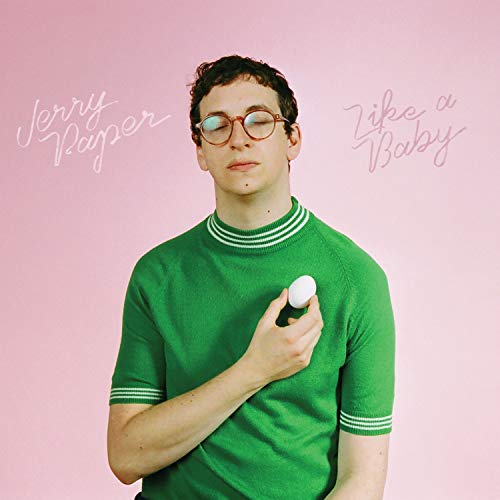 Man in green sweater holding an egg, pink background.
