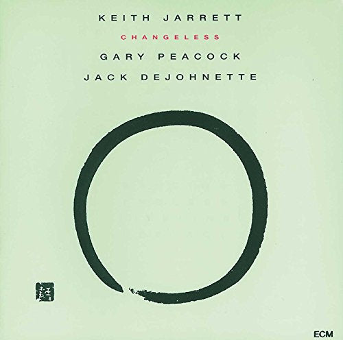 "Light green album cover with a large black circle and artist names."