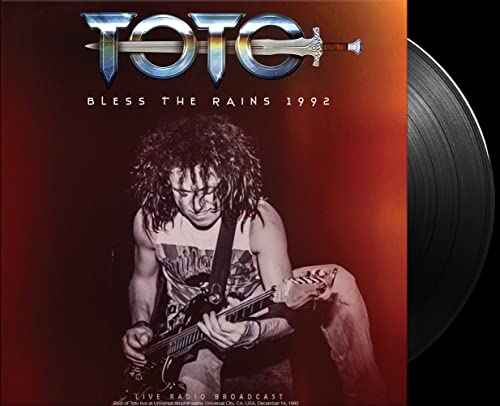 Toto album cover featuring a guitarist with a vinyl record beside it.