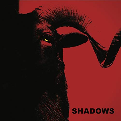Red background with a close-up of a horned animal’s face and the word “SHADOWS”.