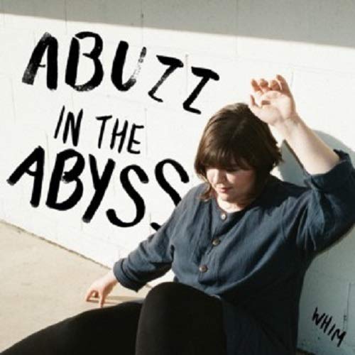 Vinyl album cover with a person sitting by a wall with handwritten text.