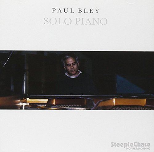 Paul Bley album cover: pianist at a grand piano, white background.