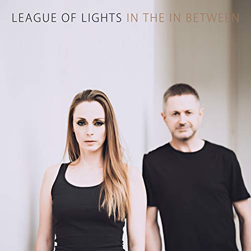 "Album cover featuring a man and woman in black against a white background."