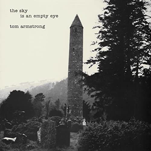 CD cover: grayscale image of a round tower against a dark landscape.