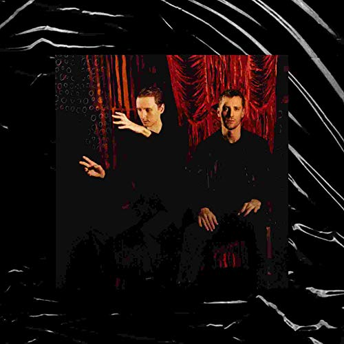 "CD cover featuring two men in black against a red curtain."