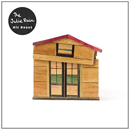 Album cover for The Julie Ruin’s “Hit Reset” featuring a wooden house.