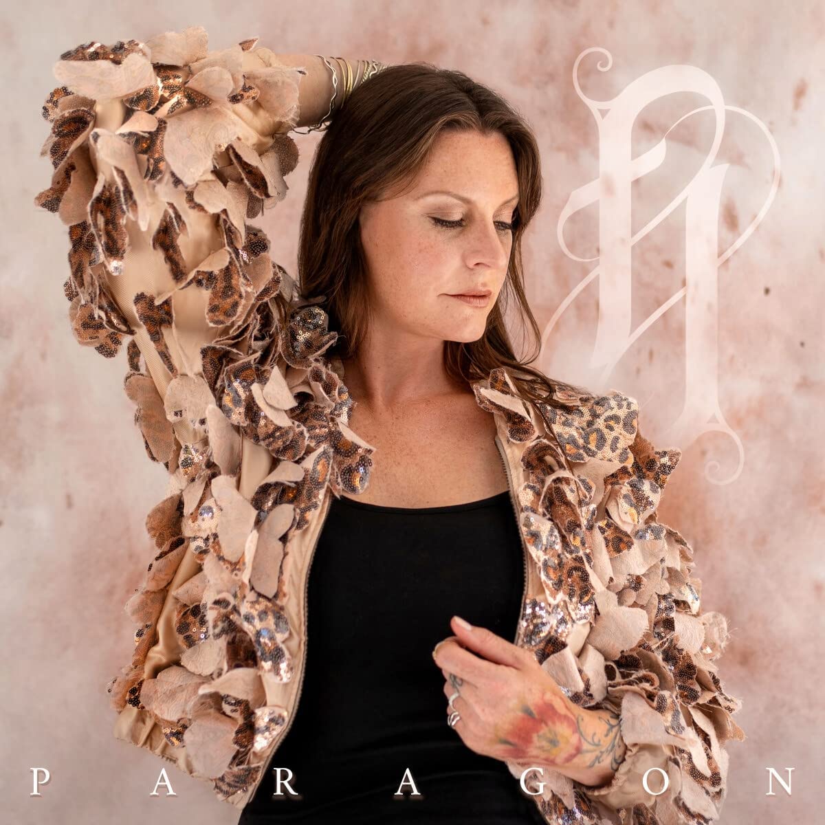 The image depicts a woman in a black top and beige jacket with the text "PARAGON".