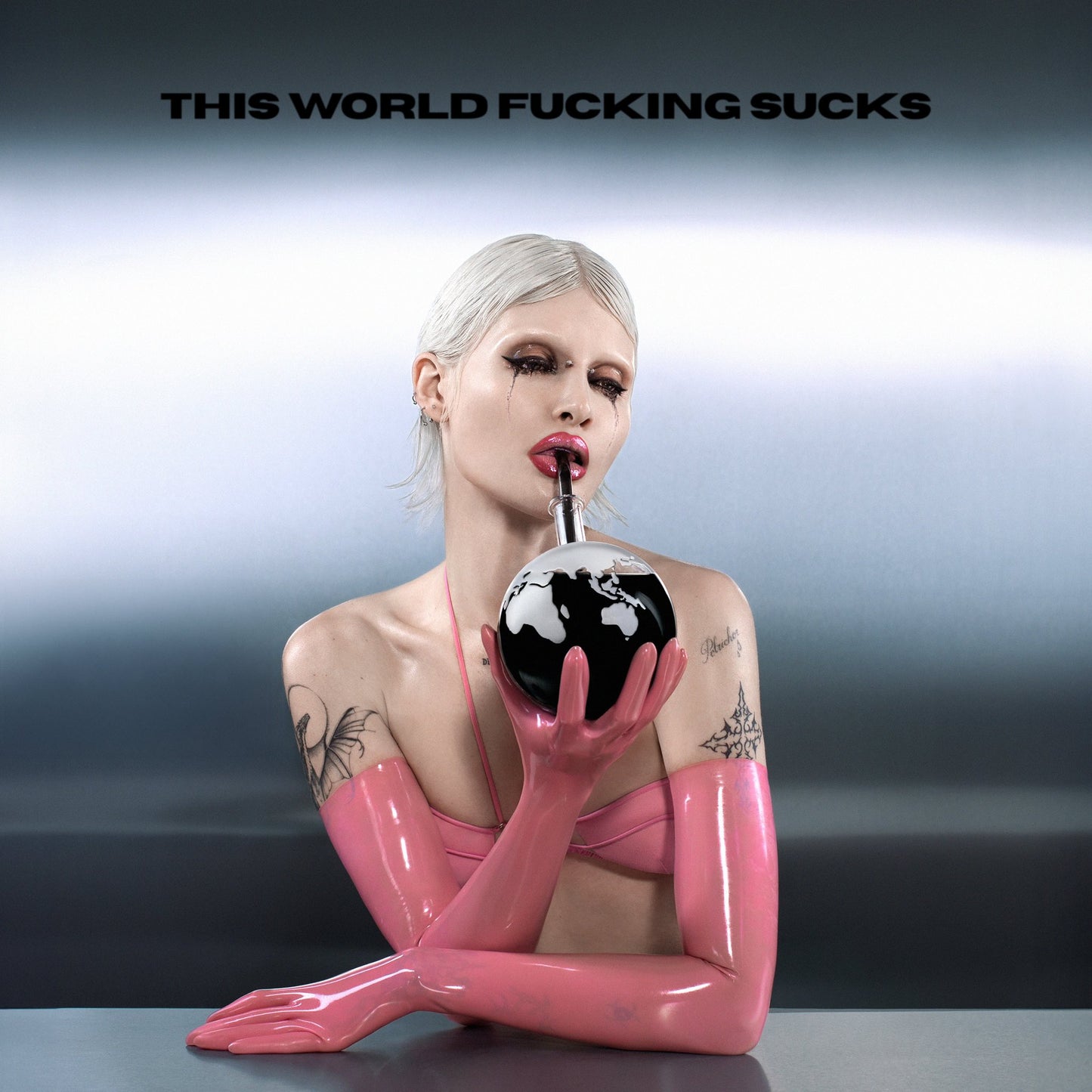 Woman with white hair drinking from a globe with a straw.