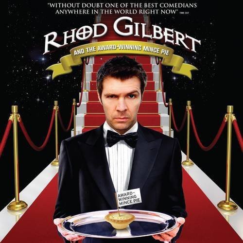 Rhod Gilbert in a tuxedo presents a mince pie on a silver platter.