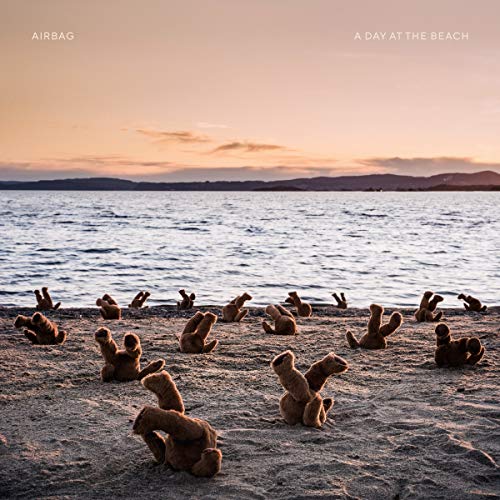 CD cover: teddy bears arranged on a sandy beach at sunset.