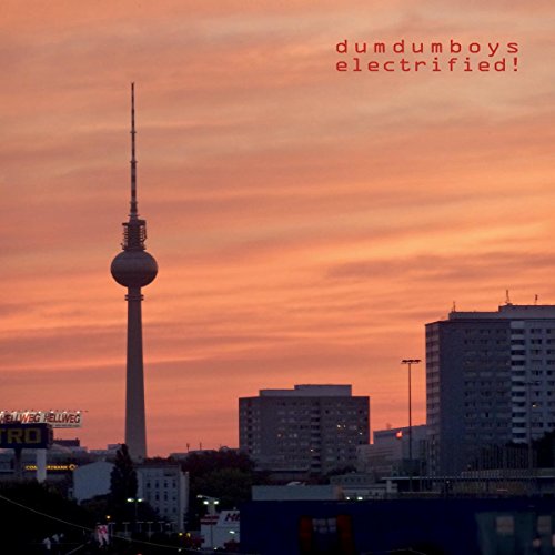 "Album cover featuring a cityscape with a tall tower at sunset, orange sky."