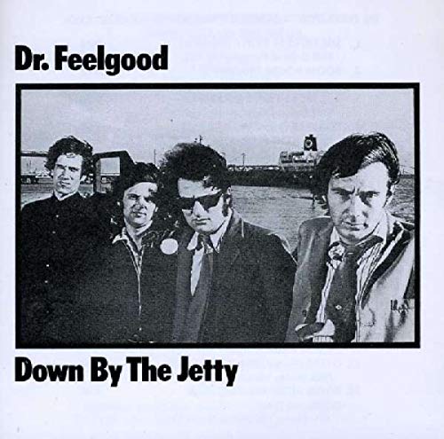 "Black and white album cover with four men standing together, outdoors."
