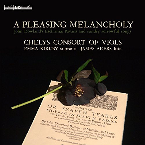 A black flower rests on a vintage sheet music page against a black background.