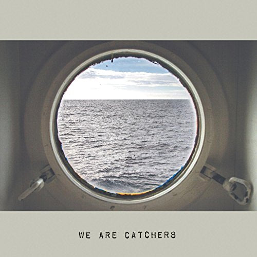 A view of the ocean through a round ship porthole with text below.