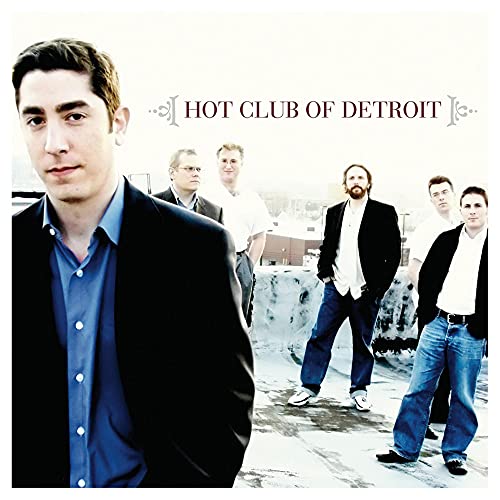 CD cover featuring a group of men in suits on a rooftop.