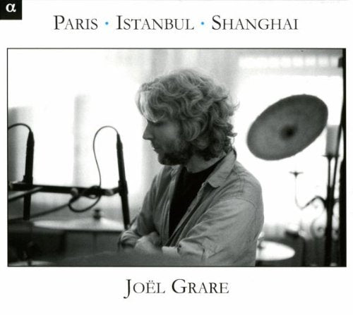 "Black and white album cover with a man sitting behind drum kit."