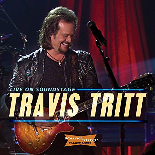 "CD cover featuring Travis Tritt playing guitar on stage with red curtains."