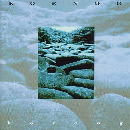 "Album cover with a blue-toned image of rocks and cloudy background."