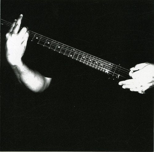 Black and white photo of hands playing a bass guitar.