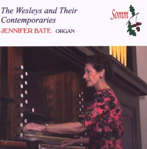"Woman playing a large organ, wearing a pink floral top, on a CD cover."