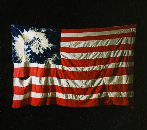 A crumpled American flag with a tie-dye pattern on a black background.
