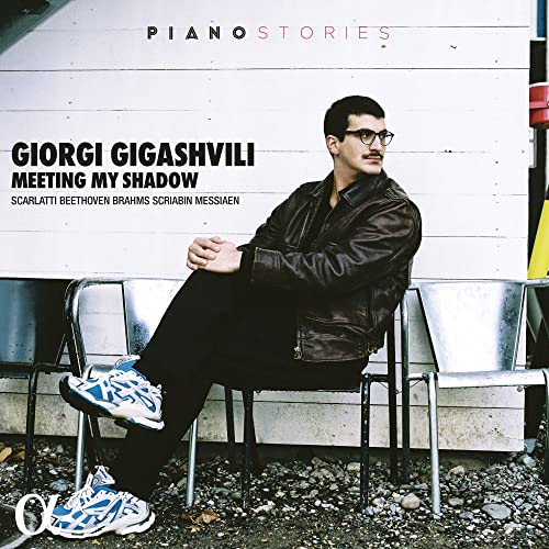 CD cover featuring Giorgi Gigashvili, a pianist, seated on metal chairs.