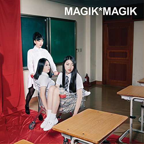 "Three young women in school uniforms posing in a classroom with red fabric."