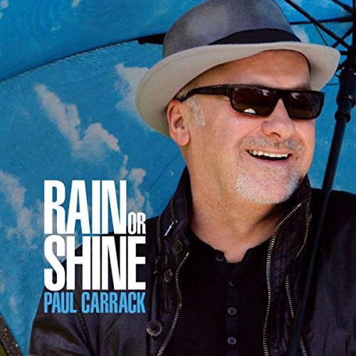 "Album cover with Paul Carrack wearing sunglasses and hat, against a blue sky."