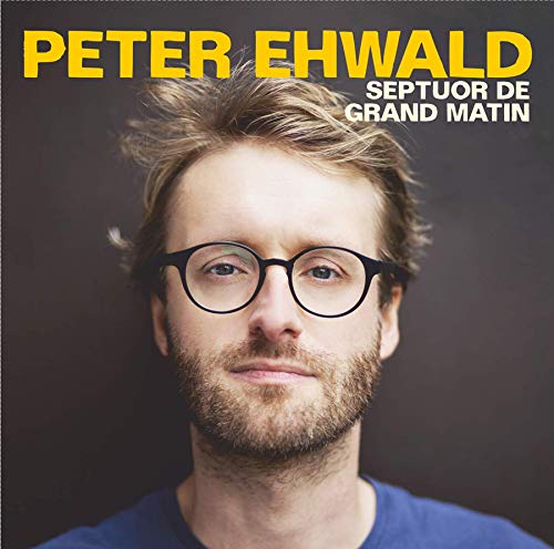 The alt text for the image is: "CD cover featuring a man with glasses and a blue shirt."