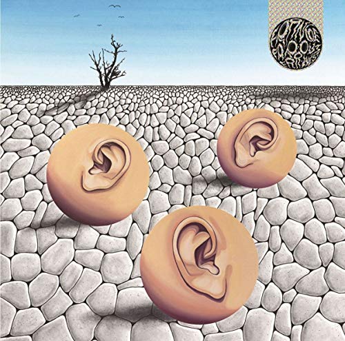 Surreal album cover with three ears as spheres in a rocky landscape.