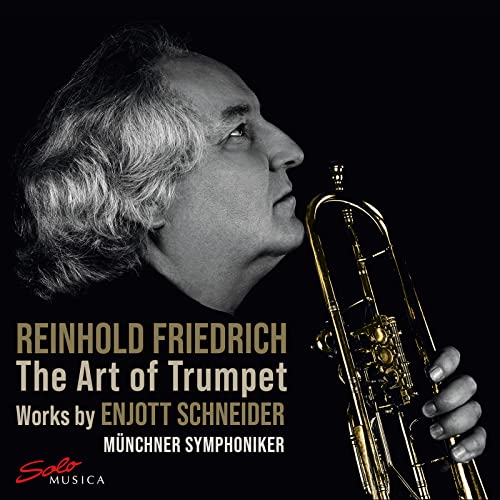 Black and white portrait of a man playing a golden trumpet.