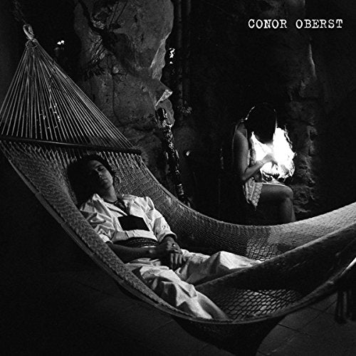 Black and white album cover featuring a person in a hammock and another by a fire.