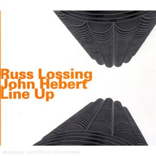"Album cover with white background, orange text, and abstract black triangular shapes."