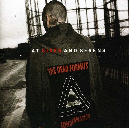 "Album cover with a man in a hoodie, facing away, with industrial background."