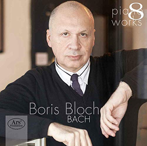 Boris Bloch in a black sweater, leaning on a chair, with text overlay.