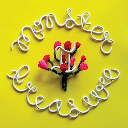 The image is a vinyl record cover featuring a bright yellow background. A bouquet of red roses is arranged to resemble a dollar sign, surrounded by white cursive text reading "Monster Treasure" in a circular pattern. The alt text for this image could be: "Yellow vinyl record cover with red roses forming a dollar sign."