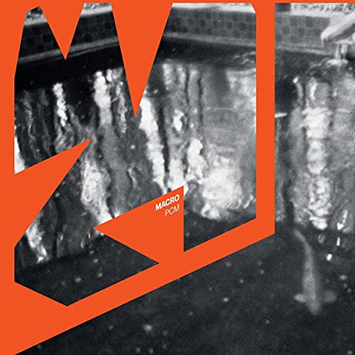 Vinyl record cover with abstract orange shapes and blurred cityscape.