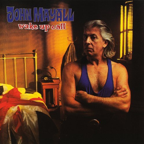 "Album cover: man in blue tank top sitting on bed with crossed arms."