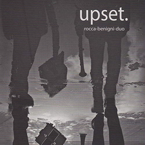 Black and white CD cover with a blurry reflection of a person and briefcase.