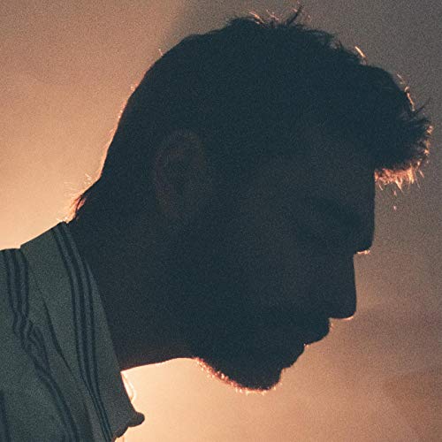 Silhouetted profile of a man with beard, against a warm orange background.