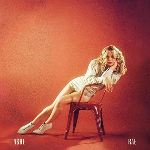 CD cover for Ashe’s “Rae” featuring a woman sitting on a red chair.
