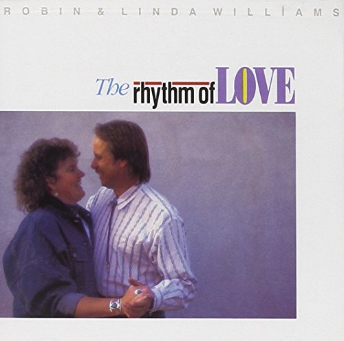 A blurry album cover with "The Rhythm of Love" text and two embracing figures.