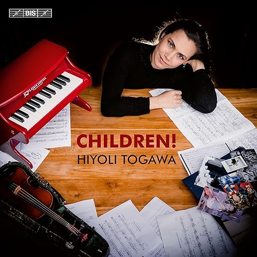 Hiyoli Togawa album cover with musician, instruments, and sheet music.
