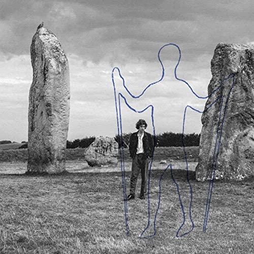 Black and white photo of a man standing between stone monoliths with blue outlines.