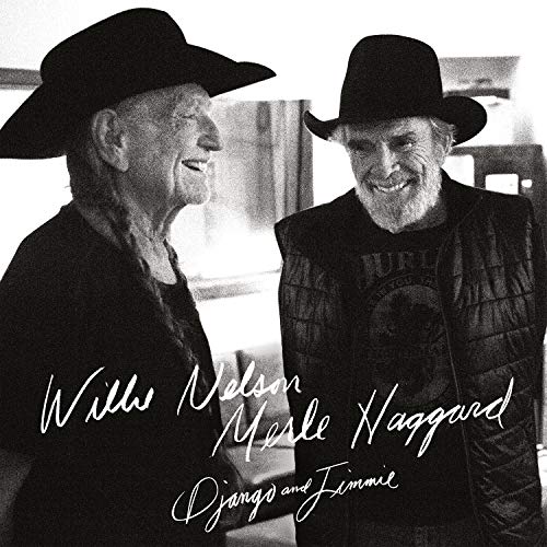 Black and white image of two older men wearing cowboy hats, smiling.
