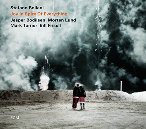 "Album cover with two people standing on a beach, smoke in the background."