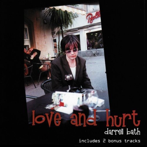 "CD cover with a man sitting at an outdoor table, wearing sunglasses."